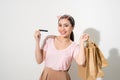 Young beautiful woman with credit card in hand and holding shopping bags over white background Royalty Free Stock Photo