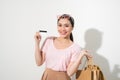 Young beautiful woman with credit card in hand and holding shopping bags over white background Royalty Free Stock Photo