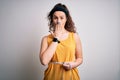 Young beautiful woman with curly hair controlling weight using tape mesure cover mouth with hand shocked with shame for mistake,