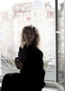 beautiful woman with curly hair drinking coffee near the open window Royalty Free Stock Photo