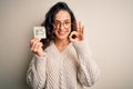 Young beautiful woman with curly hair holding reminder paper with yes word message doing ok sign with fingers, excellent symbol Royalty Free Stock Photo