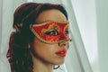 Beautiful woman with curly hair wearing a red mask and red lipstick sensitive close up  portrait Royalty Free Stock Photo