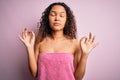 Young beautiful woman with curly hair wearing shower towel after bath over pink background relax and smiling with eyes closed Royalty Free Stock Photo