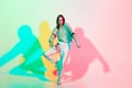 Young beautiful woman dancing hip-hop, street style isolated on studio background in neon light Royalty Free Stock Photo