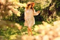 Young beautiful woman dancing in the Park. Hat and light summer dress