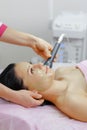 Young beautiful woman with dark hair gets procedure in the beauty salon