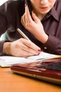 Young beautiful woman at desk writing a note.