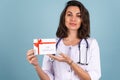 Young beautiful woman doctor in a lab coat on a blue background Royalty Free Stock Photo