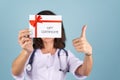 Young beautiful woman doctor in a lab coat on a blue background Royalty Free Stock Photo