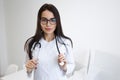 Young beautiful woman doctor with a stethoscope around her neck in the office. Royalty Free Stock Photo