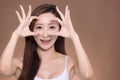 Young beautiful  woman  doing ok gesture with hand smiling, eye looking through fingers with happy face Royalty Free Stock Photo