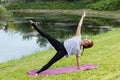 Young beautiful woman doing yoga exercise in green park. Healthy lifestyle and fitness concept. Royalty Free Stock Photo