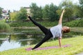 Young beautiful woman doing yoga exercise in green park. Healthy lifestyle and fitness concept. Royalty Free Stock Photo