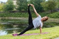 Young beautiful woman doing yoga exercise in green park. Healthy lifestyle and fitness concept. Royalty Free Stock Photo