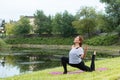 Young beautiful woman doing yoga exercise in green park. Healthy lifestyle and fitness concept. Royalty Free Stock Photo
