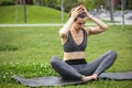 Young beautiful woman doing yoga exercise in green park near the pond. Exercices for improve the flexibility. Wellbeing Royalty Free Stock Photo