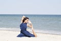 Young beautiful woman doing yoga at seaside in blue dress Royalty Free Stock Photo