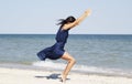 Young beautiful woman doing yoga at seaside in blue dress Royalty Free Stock Photo