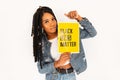 Young beautiful woman with dreadlocks in blue jeans clothes protests and holds a yellow poster Black Lives Matter.