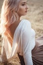 Young beautiful woman in dress with naked back on a background of dry grass, romantic girl relaxing alone in nature, natural Royalty Free Stock Photo