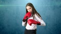 Young beautiful woman dress in white shirt standing in combat pose with red boxing gloves. Business concept. Royalty Free Stock Photo