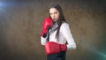 Young beautiful woman dress in white shirt standing in combat pose with red boxing gloves. Business concept. Royalty Free Stock Photo