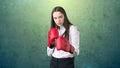 Young beautiful woman dress in white shirt standing in combat pose with red boxing gloves. Business concept. Royalty Free Stock Photo