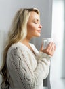 Young and beautiful woman drinking coffee and looking it to the window Royalty Free Stock Photo