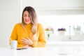 Young beautiful woman drinking a cup of coffee at home with hand on stomach because nausea, painful disease feeling unwell