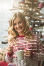 Young beautiful woman drinking cup of coffee blurred winter snow tree background. Royalty Free Stock Photo