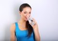 Young beautiful woman drinking fresh pure water from glass on bl