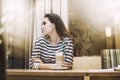 Young beautiful woman drinking latte in the coffee shop at a tab Royalty Free Stock Photo