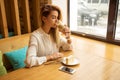 Young beautiful woman drinking latte in coffeeshop