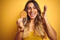 Young beautiful woman eating biscuit over grey isolated background very happy and excited, winner expression celebrating victory Royalty Free Stock Photo