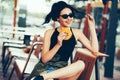 Young beautiful woman eating burger and enjoying while sitting outdoor. Fastfood Unhealthy Lifestyle Fashion Food concepts Royalty Free Stock Photo