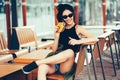 Young beautiful woman eating burger and enjoying while sitting outdoor. Fastfood Unhealthy Lifestyle Fashion Food concepts Royalty Free Stock Photo