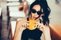 Young beautiful woman eating burger and enjoying while sitting outdoor. Fastfood Unhealthy Lifestyle Fashion Food concepts Royalty Free Stock Photo