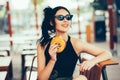 Young beautiful woman eating burger and enjoying while sitting outdoor. Fastfood Unhealthy Lifestyle Fashion Food concepts Royalty Free Stock Photo