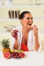 Young beautiful woman eating grapes from a fruit bowl Royalty Free Stock Photo