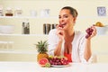 Young beautiful woman eating grapes from a fruit bowl Royalty Free Stock Photo