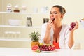 Young beautiful woman eating grapes from a fruit bowl Royalty Free Stock Photo