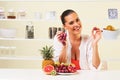 Young beautiful woman eating grapes from a fruit bowl Royalty Free Stock Photo
