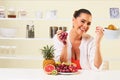 Young beautiful woman eating grapes from a fruit bowl Royalty Free Stock Photo