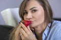 Young, beautiful woman eating strawberries. Relaxing home, desire face expression and romantic pose.