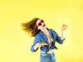 Young beautiful woman eats hold pepperoni pizza slice opening her mouth on yellow background Royalty Free Stock Photo