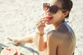 Young beautiful woman eats watermelon on the beach