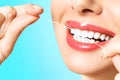 Young beautiful woman is engaged in cleaning teeth. Beautiful smile healthy white teeth. A girl holds a dental floss Royalty Free Stock Photo