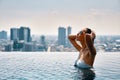 Young beautiful woman enjoy summer vacation on swimming pool in hotel roof top Royalty Free Stock Photo