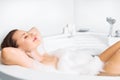 Young woman enjoying bathing in bathtub