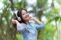 Young beautiful woman enjoying music in the garden listening to music with headphones Royalty Free Stock Photo